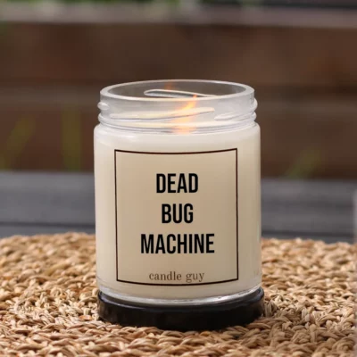 Burning anti-mosquito candle with the quote “Dead Bug Machine” in a white jar in a cozy setting